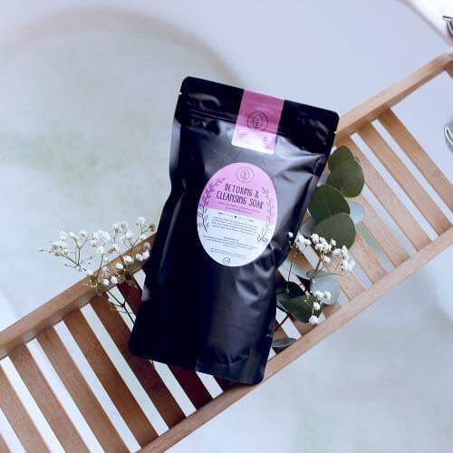 ZestySpiritz Detox and Cleansing Bath Soak 700g in a clear container with natural ingredients and calming colors.