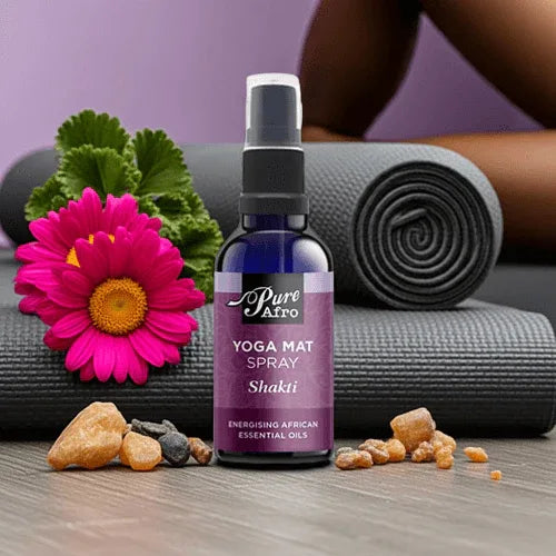 Energising yoga mat spray on a yoga mat with flowers and essential oils, promoting freshness and vitality in workouts.