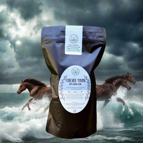 Anti-Aging Bath Soak with Bergamot - Forever Young 700g in elegant packaging by the ocean with galloping horses.