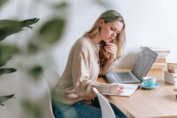 Woman studying with laptop and notebook in the natural focus and calm study set.