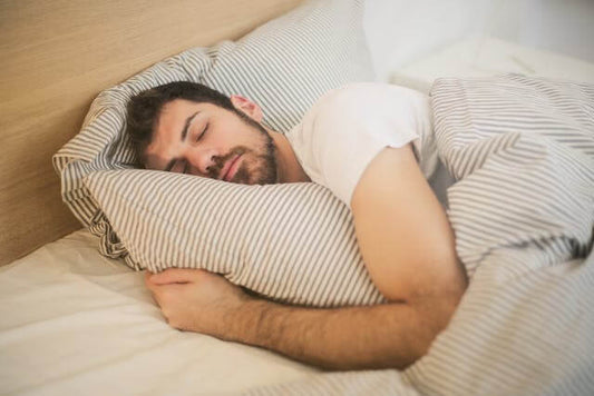 Man sleeping peacefully in bed, representing a 10-minute bedtime ritual for better sleep.
