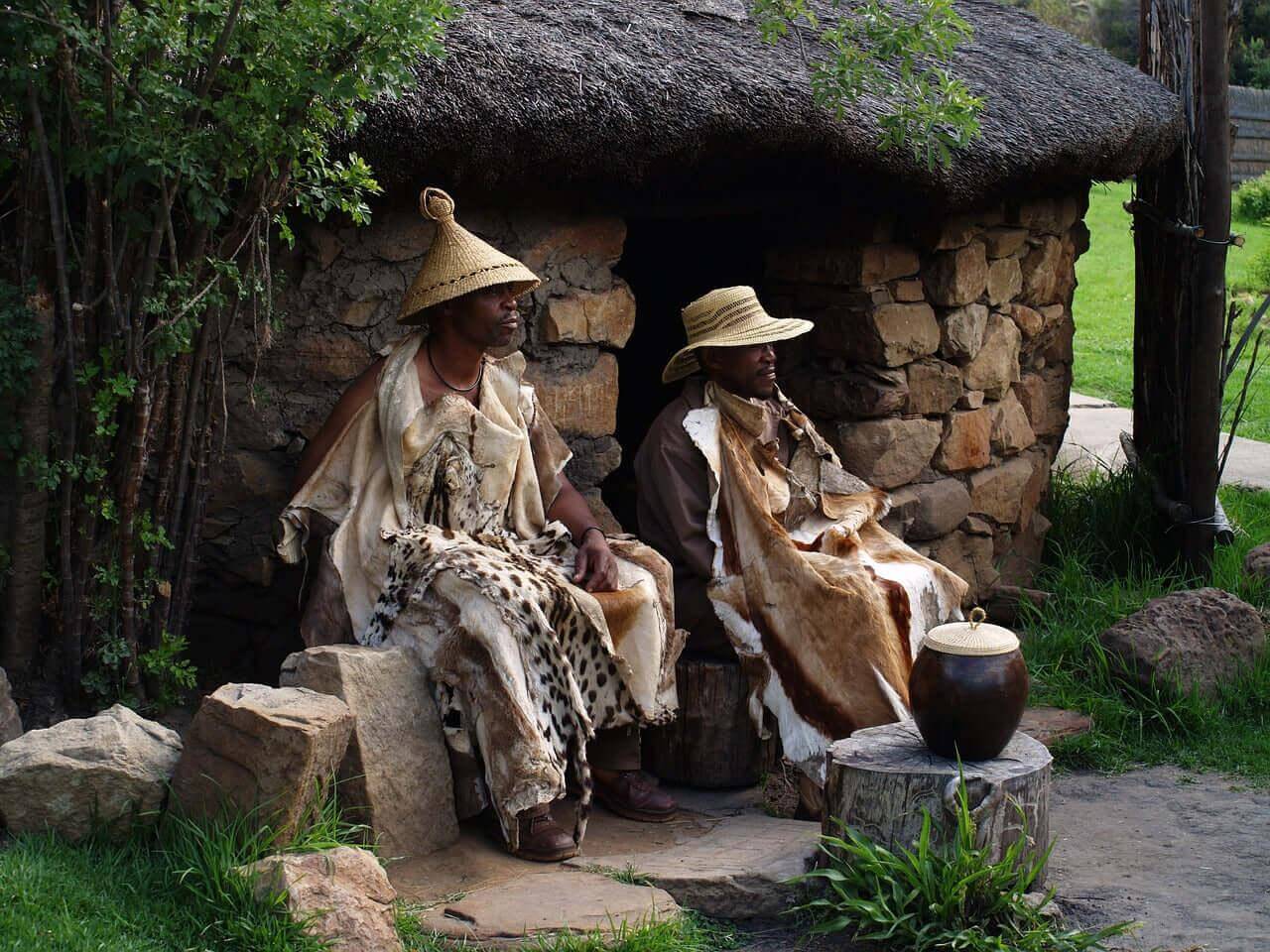 Homegrown South Africa collection showcasing local artisans in traditional attire outside a stone hut.