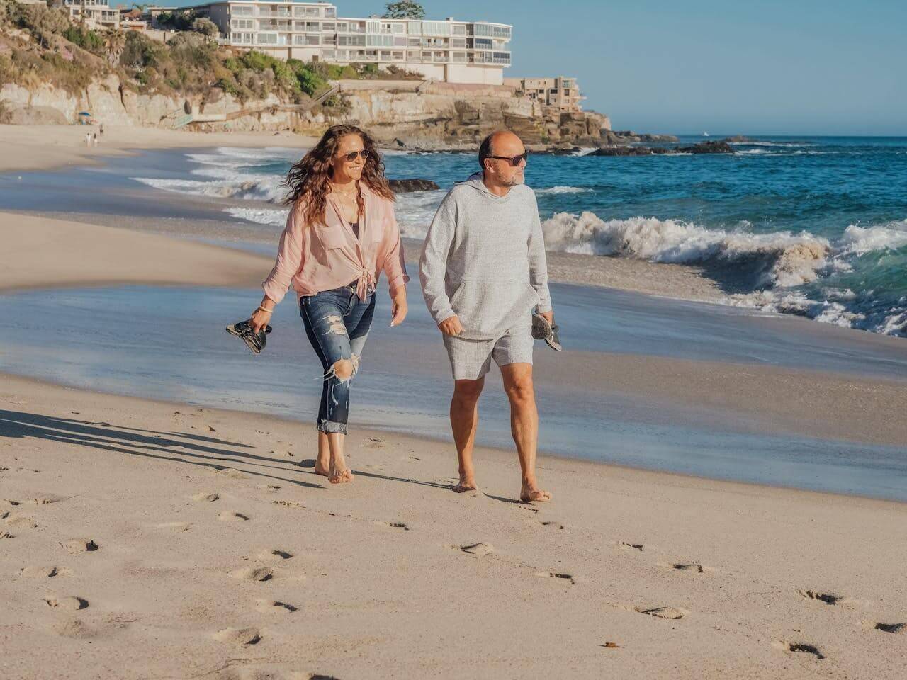 A couple walking on the beach, promoting bone and joint health products for active living.